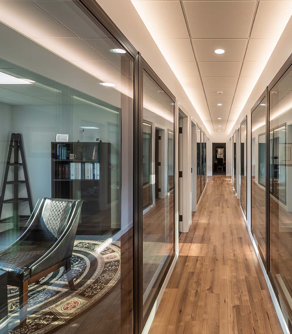 Hallway in firm's office building, lined with glass walls